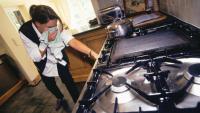 A woman turns off the stove in her kitchen